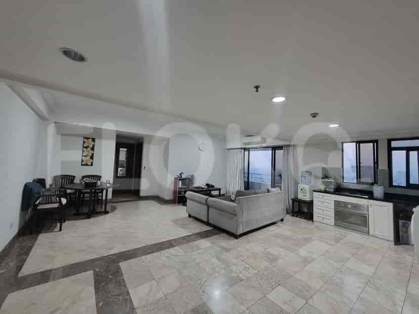 A combined living, dining, and kitchen area with marble flooring and large windows.