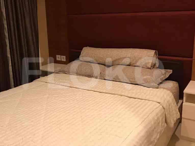 Bedroom featuring a bed with pillows, bedside tables, and a decorative headboard.