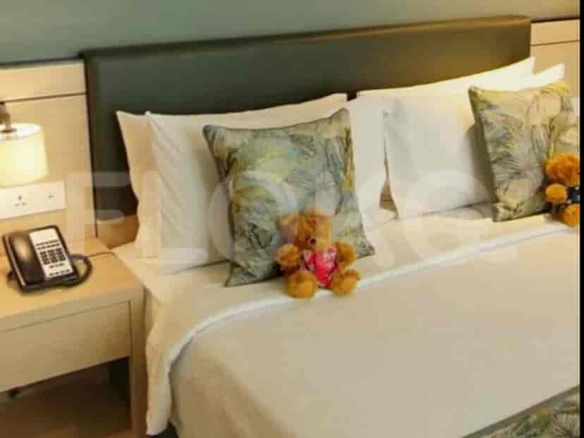 A bedroom featuring a queen-sized bed, a nightstand, and a lamp.