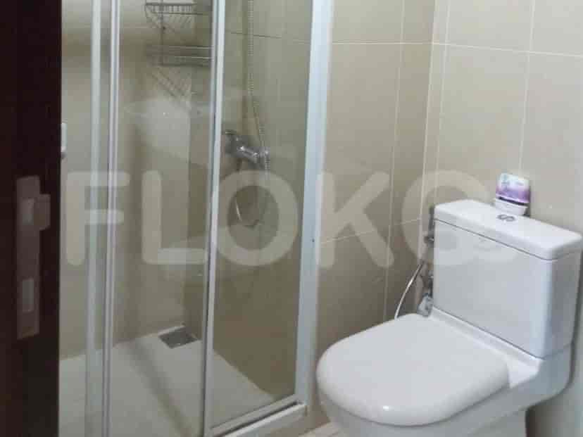 A small bathroom with a shower and toilet.