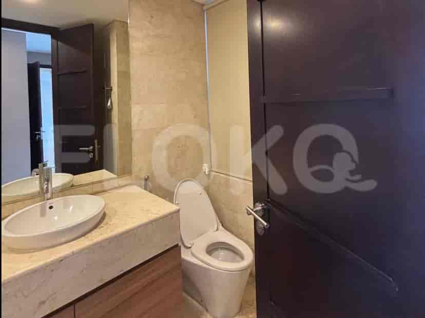 A bathroom featuring a marble vanity, toilet, and mirror.