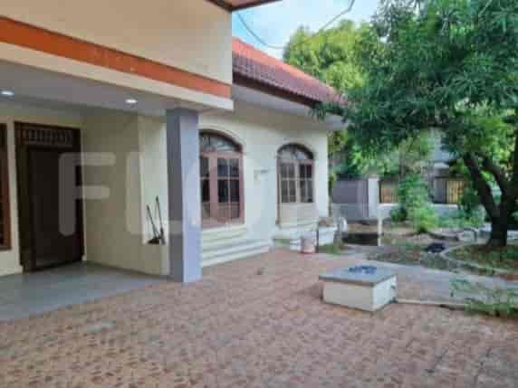A front porch with tiled flooring, an outdoor seating area, and a large tree.