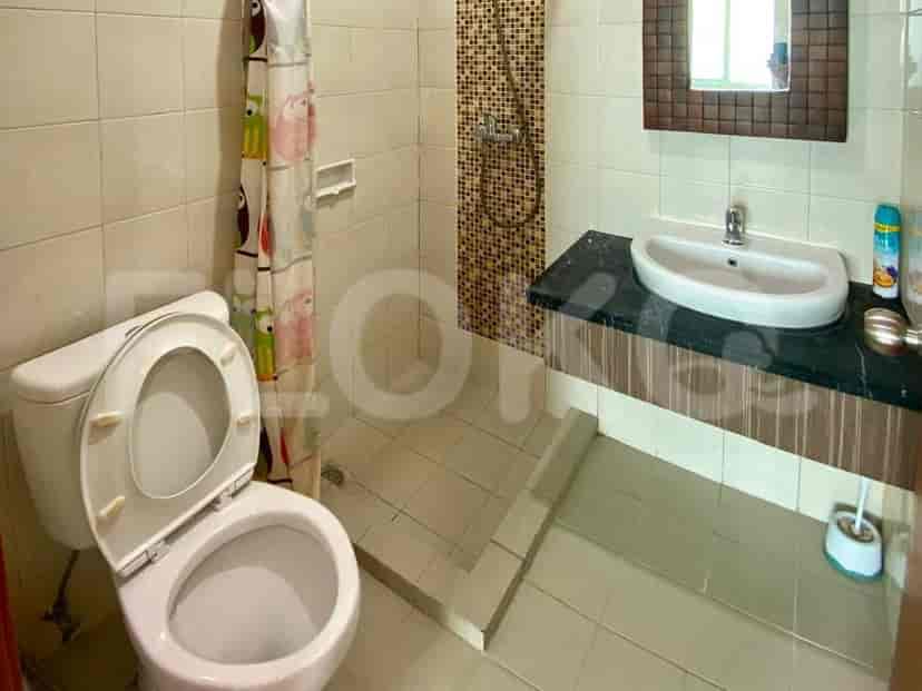 Compact bathroom with a toilet, shower area, and a wall-mounted sink.
