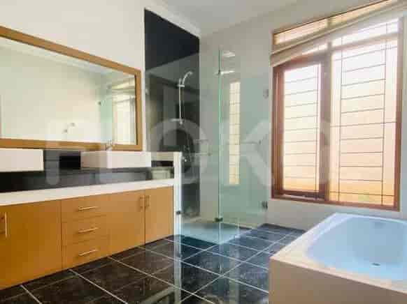A modern bathroom with a double vanity, glass-enclosed shower, and a large bathtub.
