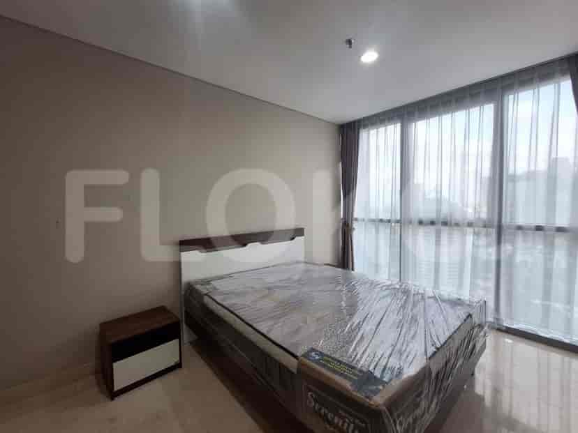A bedroom with a large bed and floor-to-ceiling windows.