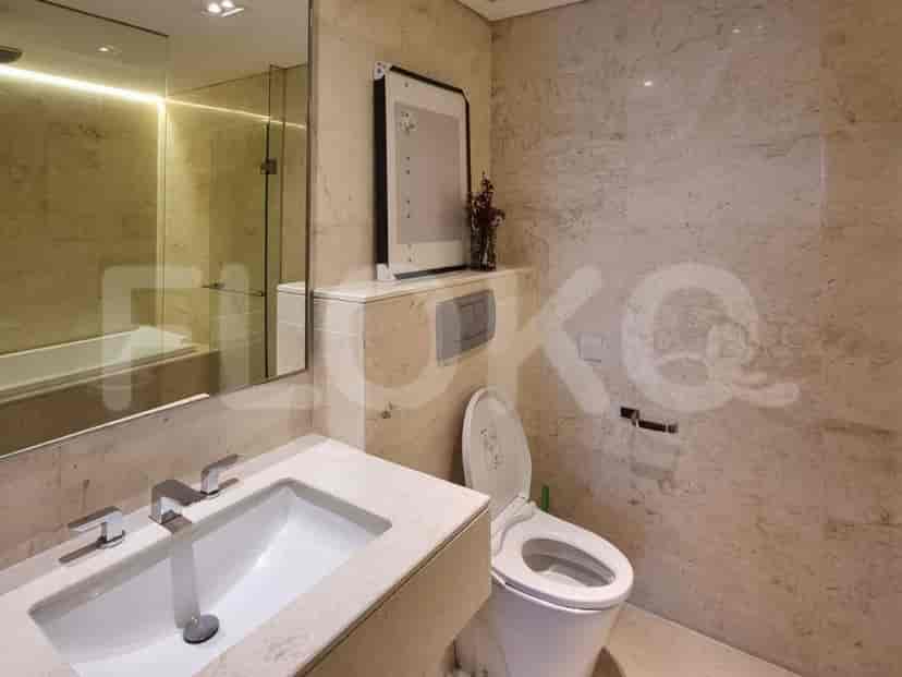 A luxurious bathroom with a marble vanity, sink, toilet, and bathtub.