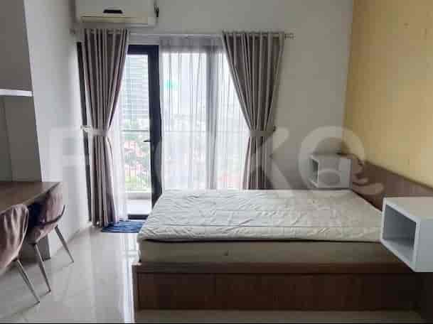 A bedroom with a bed, desk, and large window with curtains.