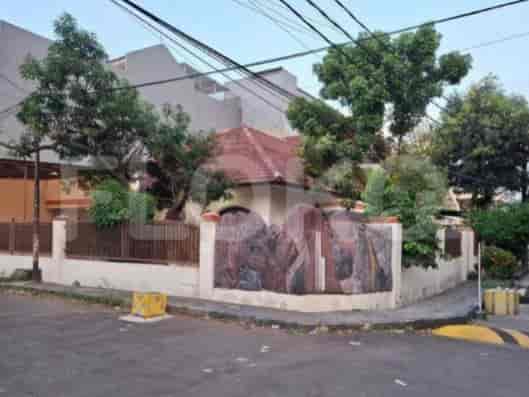 A house exterior with a tiled roof, decorative fence, and surrounding greenery.