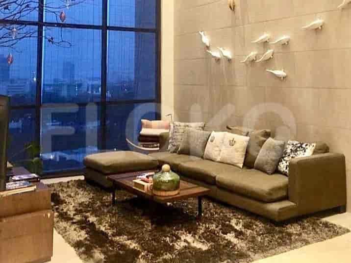 Spacious living room with an L-shaped grey sofa, coffee table, and large window.