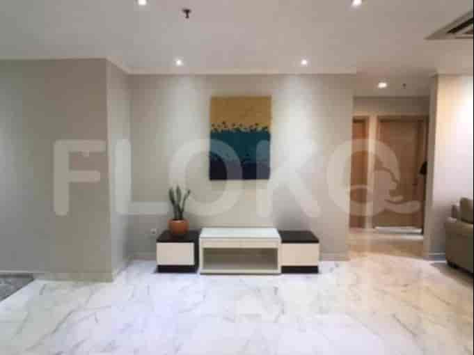 A modern living room featuring a white entertainment center with a painting above and a sofa.