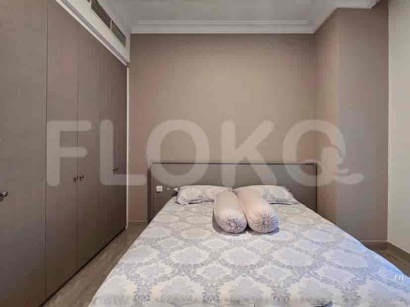 A bedroom with a queen-size bed, built-in wardrobes, and matching bedside tables.