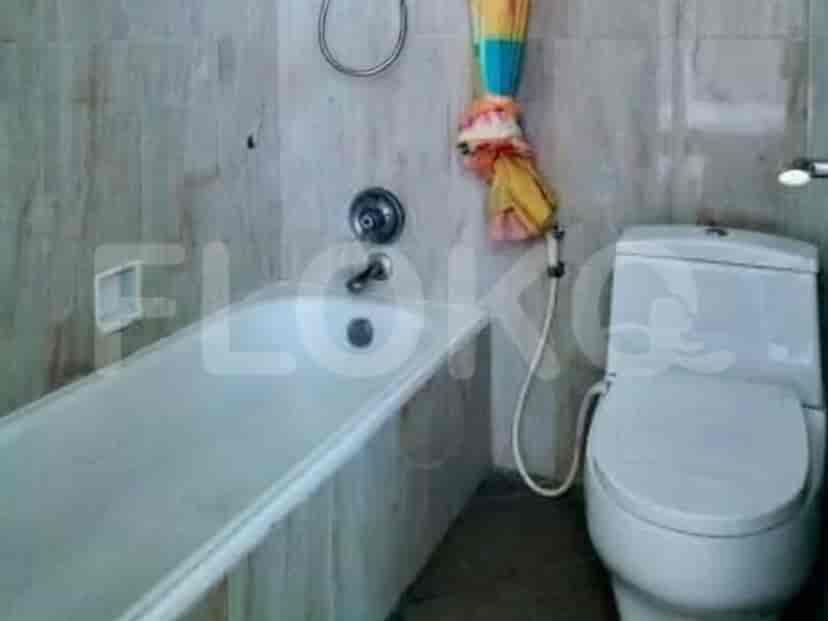A bathroom with a bathtub, toilet, and tiled walls.