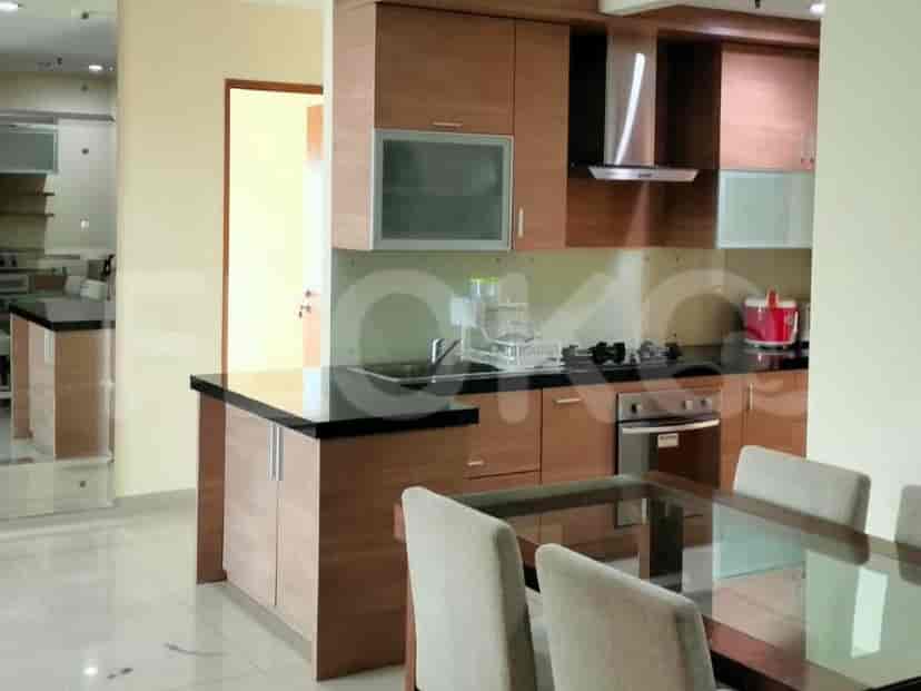 Sebuah dapur modern dengan lemari kayu, countertops granit, dan set makan.
