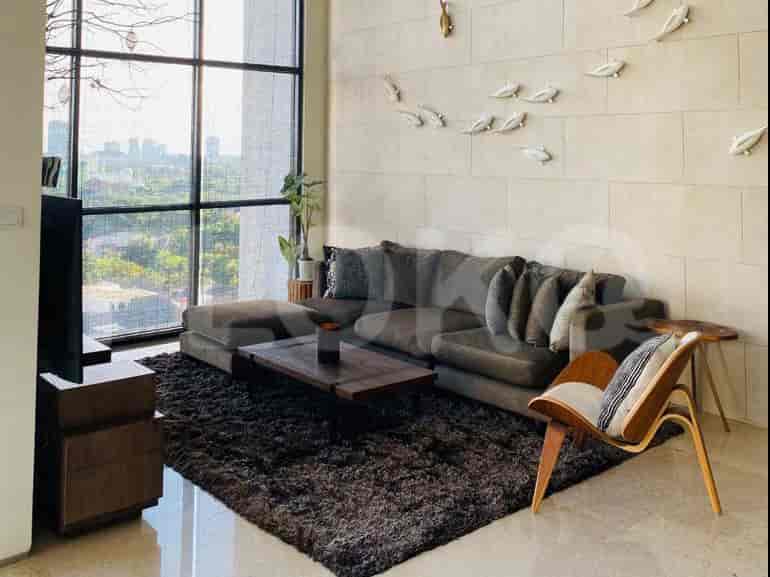 Modern living room with L-shaped sofa, coffee table, and large windows with city view.