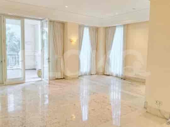 A large living room with marble floors, white walls, and sheer curtains.