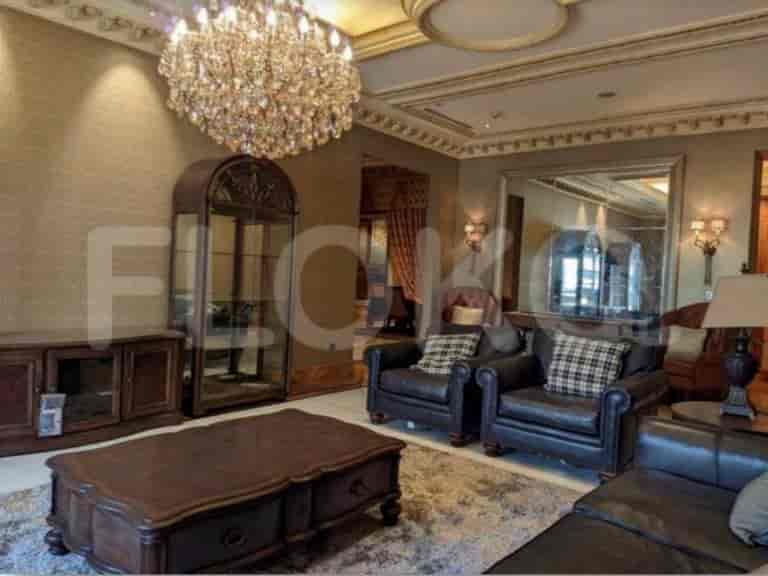 A luxurious living room featuring a chandelier, dark leather furniture, and elegant decor.