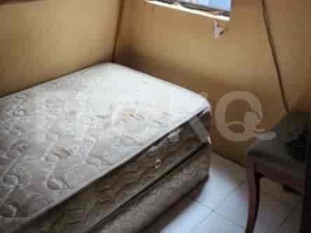 Small bedroom with a bed and a small side table.