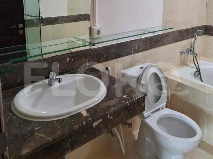Kamar mandi dengan wastafel, toilet, dan bak mandi, menampilkan meja marmer dan dinding berubin.