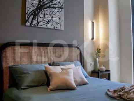 Bedroom with bed, art, and bedside table.