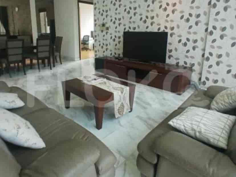 A living room with a leather sofa, coffee table, and a TV stand with a mounted TV.