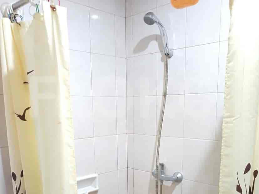 A simple bathroom with a tiled shower stall and a shower curtain.