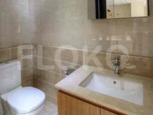A modern bathroom with a toilet, sink, and mirror.