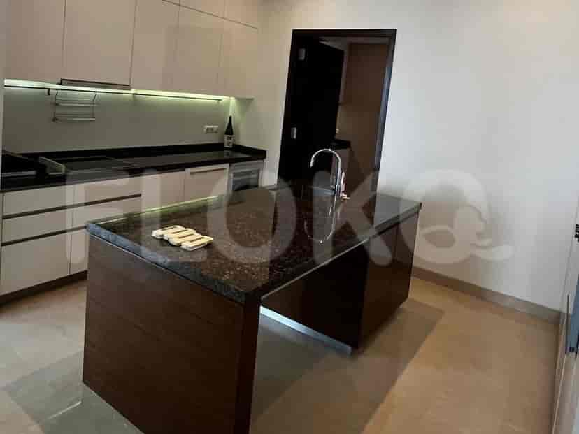 A modern kitchen with sleek cabinets, a granite countertop island with a sink, and pendant lighting.