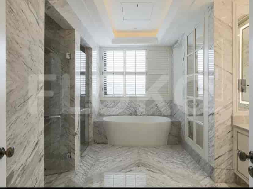 A spa-like bathroom with a bathtub, shower, and marble finishes.