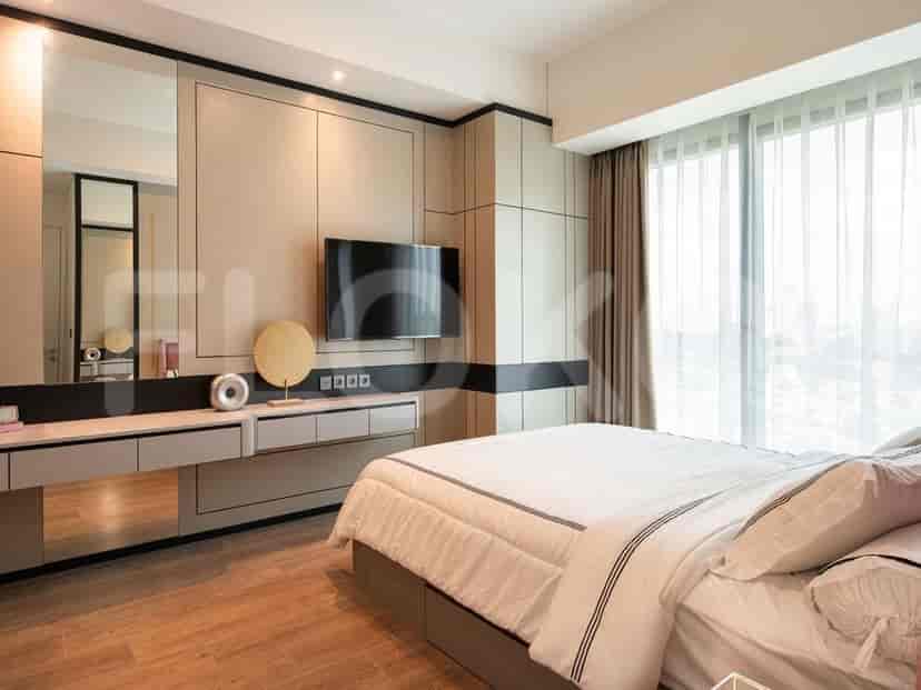 A luxurious master bedroom with a king-size bed, a dressing table, and a wall-mounted TV.