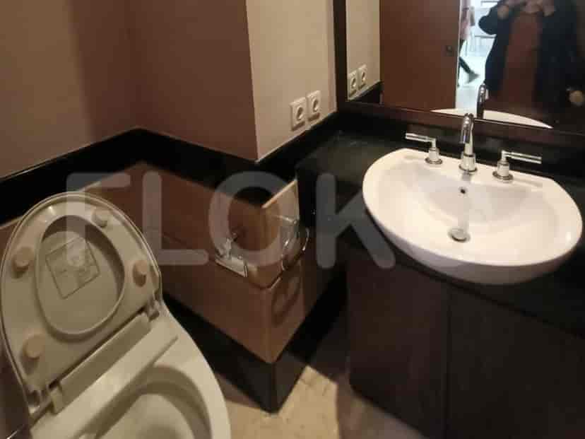 A modern bathroom with a white sink and a toilet.