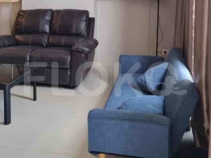 Living room with a blue sofa, brown leather recliner and a black coffee table.