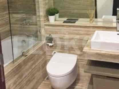 A modern bathroom featuring a bathtub, a toilet, and a large mirror.