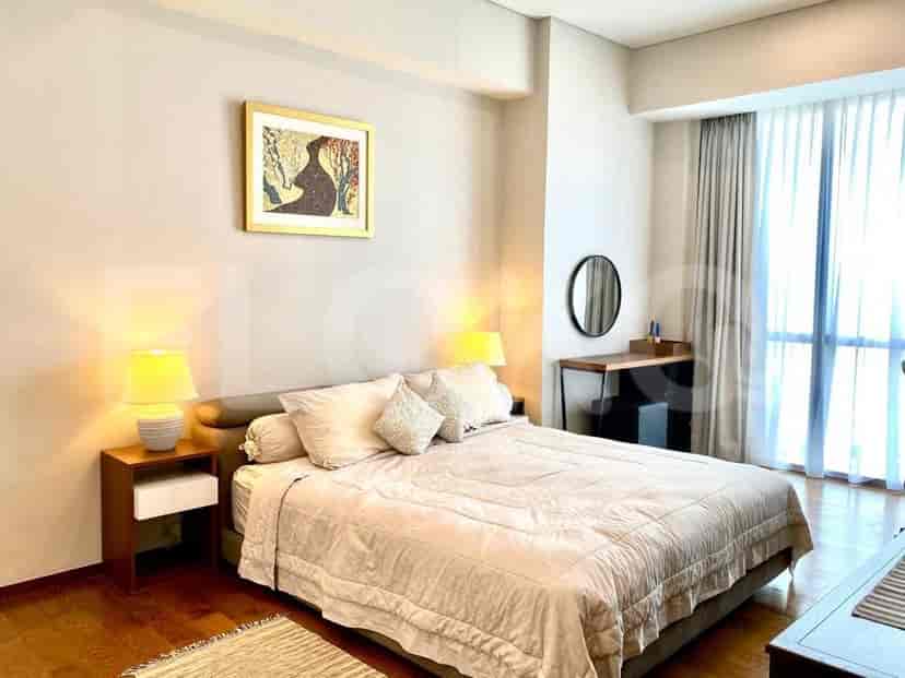 A bedroom with a queen-size bed, side tables, dresser, and a large window.