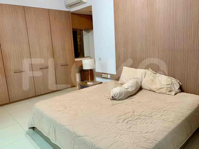 A bedroom with a large bed, wooden headboard and wardrobe.