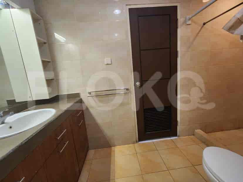 A bathroom with tiled walls and floor, a sink, a vanity, and a door.