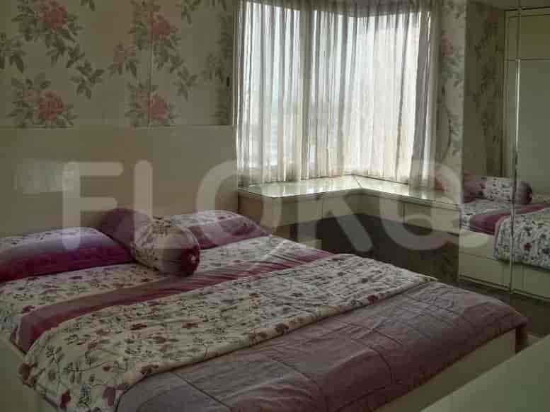 A compact bedroom with a single bed and overhead cabinets.