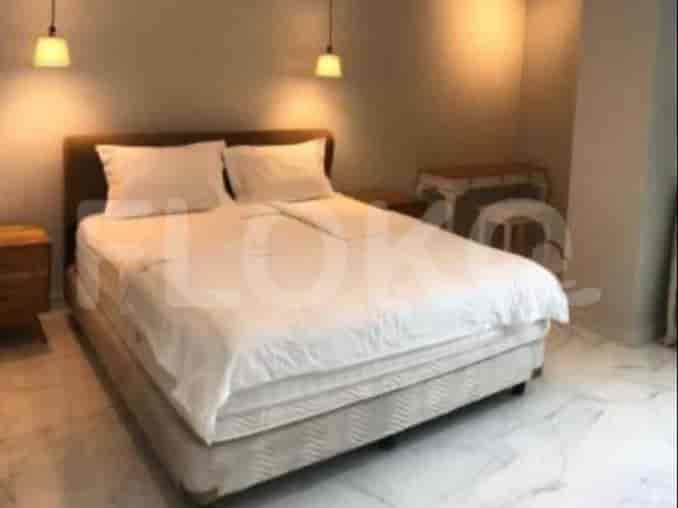 A well-lit bedroom with a large bed, neutral decor, and minimalist design.