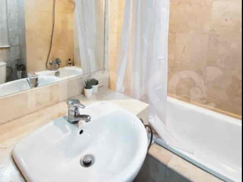 A bathroom with a bathtub, sink, and mirror.