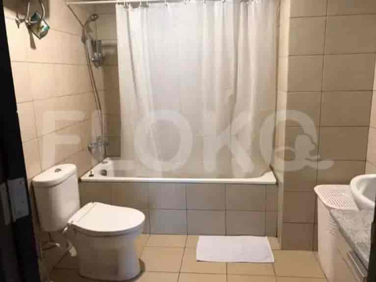 A bathroom with a toilet, bathtub, shower curtain, and sink.