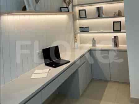 Home office with a desk, laptop, and shelving.
