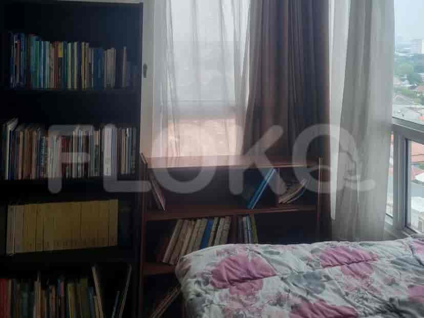 Bedroom with two beds, bookshelves, and a view.