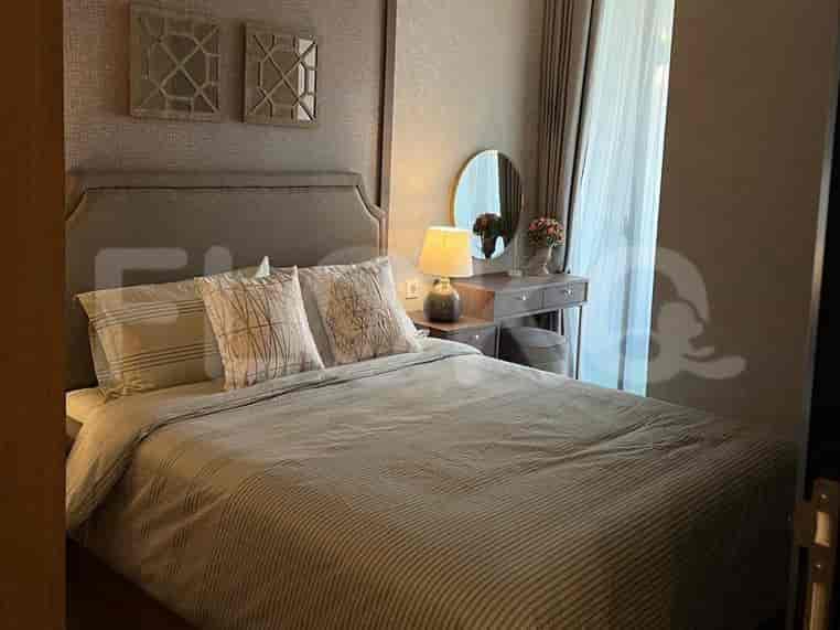 A bedroom with a queen-size bed, bedside tables, and a vanity area with a mirror and stool.