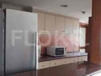A kitchen with cabinets, a microwave, and a refrigerator.