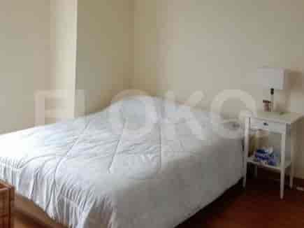 A bedroom featuring a bed with white bedding and a bedside table.