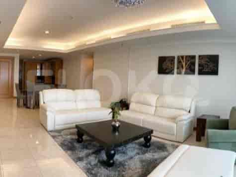 Sudut lain ruang tamu yang menunjukkan sofa, meja kopi, dan pemandangan area dapur.