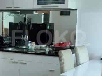 Area dapur modern dengan meja dapur gelap, wastafel, keran, dan lemari.