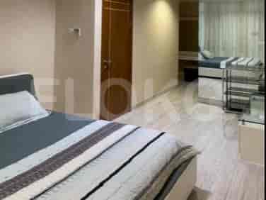 Bedroom with two beds, hardwood flooring, and a closed door.