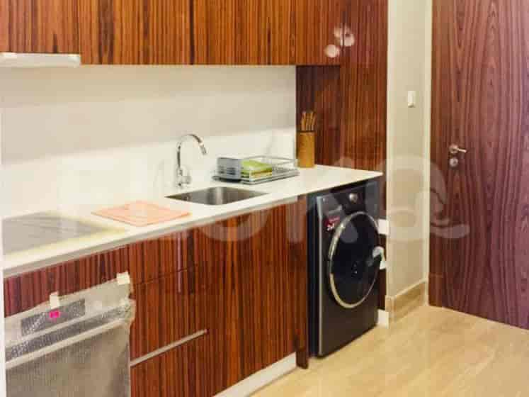 A modern kitchen with wooden cabinetry, a white countertop, and integrated appliances.