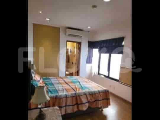 A bedroom with a bed, air conditioner, and window with curtains.