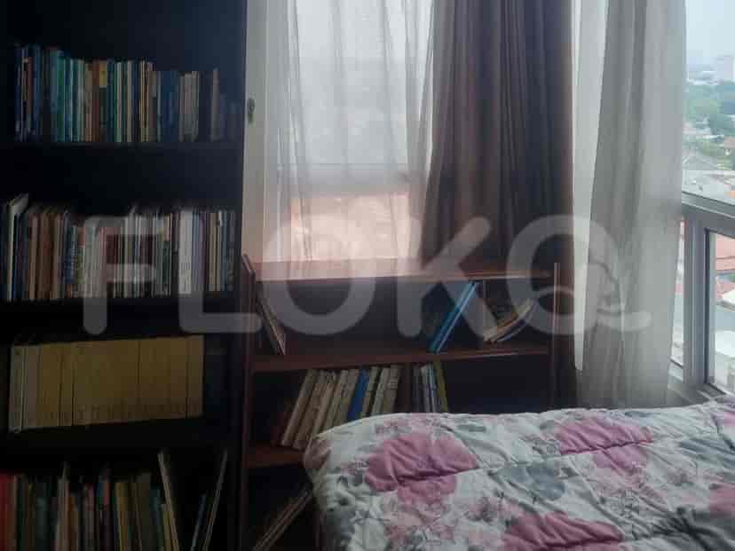 Bedroom with multiple bookshelves and a bed.